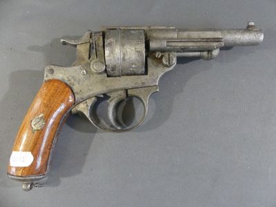 an old revolver with a wooden handle on a gray surface