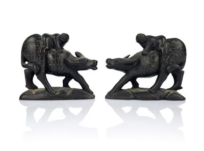 two figurines of elephants on a white surface