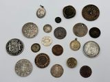 several different types of silver and bronze coins on a white surface
