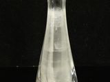 a clear glass vase sitting on a black surface