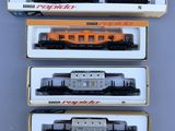 trois trains emballés sont posés dans une boîte sur une table