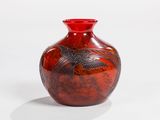 a red vase with a bird on it on a white surface