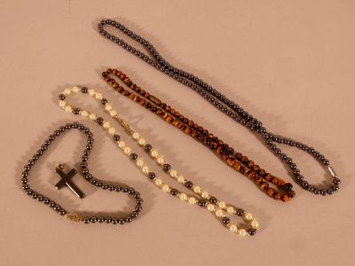 trois grains de chapelet et une croix sur un fond blanc