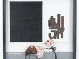 tableau représentant un homme et une femme assis sur un banc devant un tableau noir