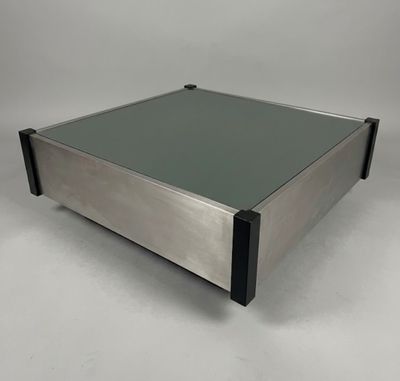 a glass coffee table with metal legs and a glass top
