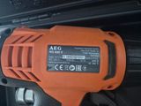 a close up of an orange electric drill with a black and white background