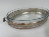 a glass tray with a metal handle on a table