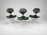 trois chaises noires et blanches placées les unes à côté des autres sur une surface blanche