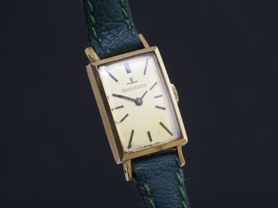 une photo d'une montre-bracelet plaquée or avec un bracelet vert