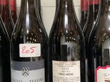 plusieurs bouteilles de vin sont alignées sur une étagère
