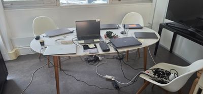 une table sur laquelle sont posés plusieurs ordinateurs portables, dans une pièce