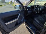 the interior of a car with the door open and the driver ' s seat down