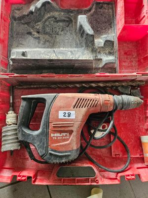 une boîte rouge contenant une perceuse et un marteau