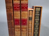 trois vieux livres posés l'un sur l'autre sur une table