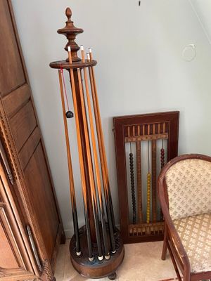 a picture of a room with a chair and a rack of pool cues
