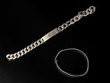 bracelet et bague en argent posés sur une surface noire avec un fond noir