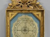 une horloge avec un cadre doré accrochée au mur