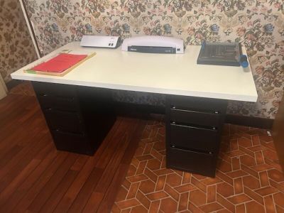 a desk with a laptop and a printer on it