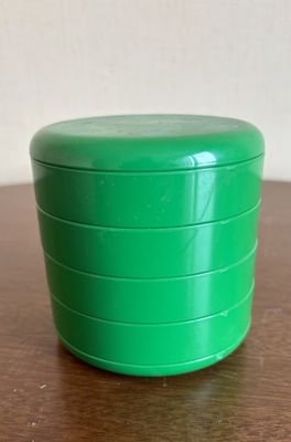 un récipient vert posé sur une table en bois