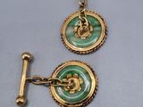 pair of gold and green buttons on a silver surface