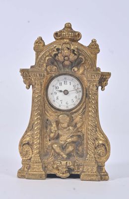 a gold clock that is sitting on a white surface