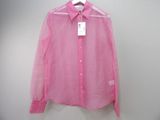 une chemise rose suspendue à un cintre sur un mur blanc
