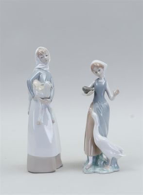 pair of porcelain figurines of a woman and a man with a dog