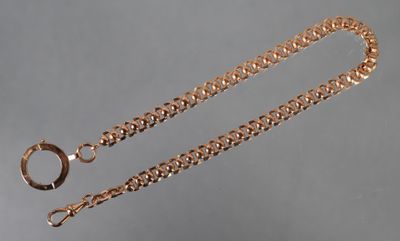 gros plan d'une chaîne en or sur laquelle est fixée une bague