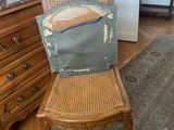 a wooden chair with a cushion on it in a room