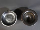 two silver pots sitting next to each other on a table