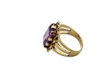 a close up of a gold ring with a purple stone