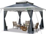 un gazebo avec des rideaux et une table entourée de chaises