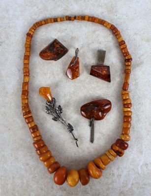 une photo d'un collier orné de divers bijoux sur un fond blanc