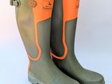 une paire de bottes vertes avec des bordures orange sur fond blanc