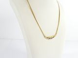 a white mannequin torso with a gold necklace on it