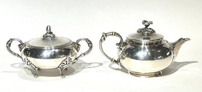 pair of silverplated teapots with ornate handles and handles