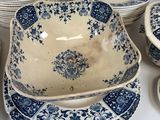 a lot of blue and white plates and bowls on the table