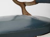 a blue cushion on the back of a white chair