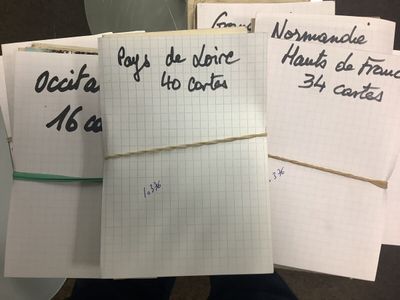 une personne tenant une liasse de feuilles sur lesquelles sont écrites des notes