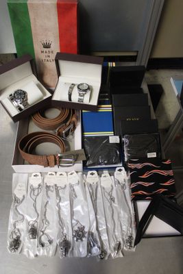 a lot of watches, belts, and other items on the table