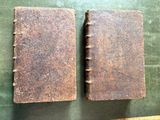 two old books sitting on top of a table next to each other