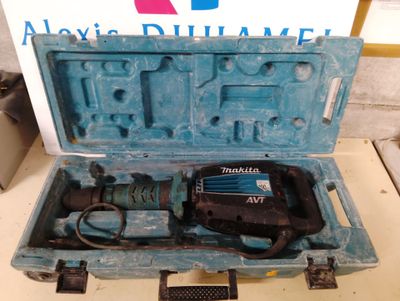 une boîte bleue contenant une perceuse, posée sur une table
