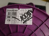 a purple spool with a sticker on it sitting on a table