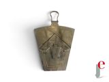 a small brass bell hanging on a white wall