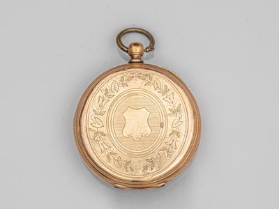 une montre de poche ancienne en or, sur laquelle est gravé le visage d'une femme