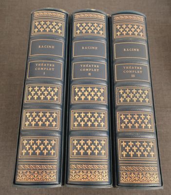 trois livres sont alignés sur une table