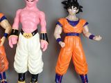 dragon ball action figures are lined up in a row on a gray surface