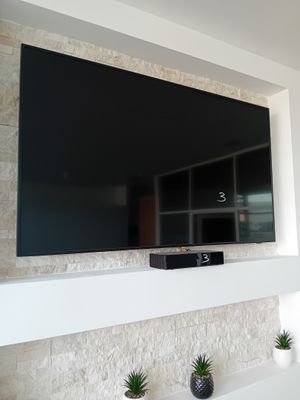 un grand téléviseur à écran plat fixé au mur au-dessus d'une cheminée