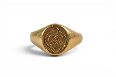 Gros plan sur une bague en or ornée d'une pièce de monnaie