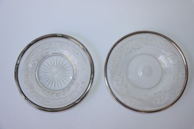 paire d'assiettes en verre transparent à bordure argentée, posées sur un plateau blanc